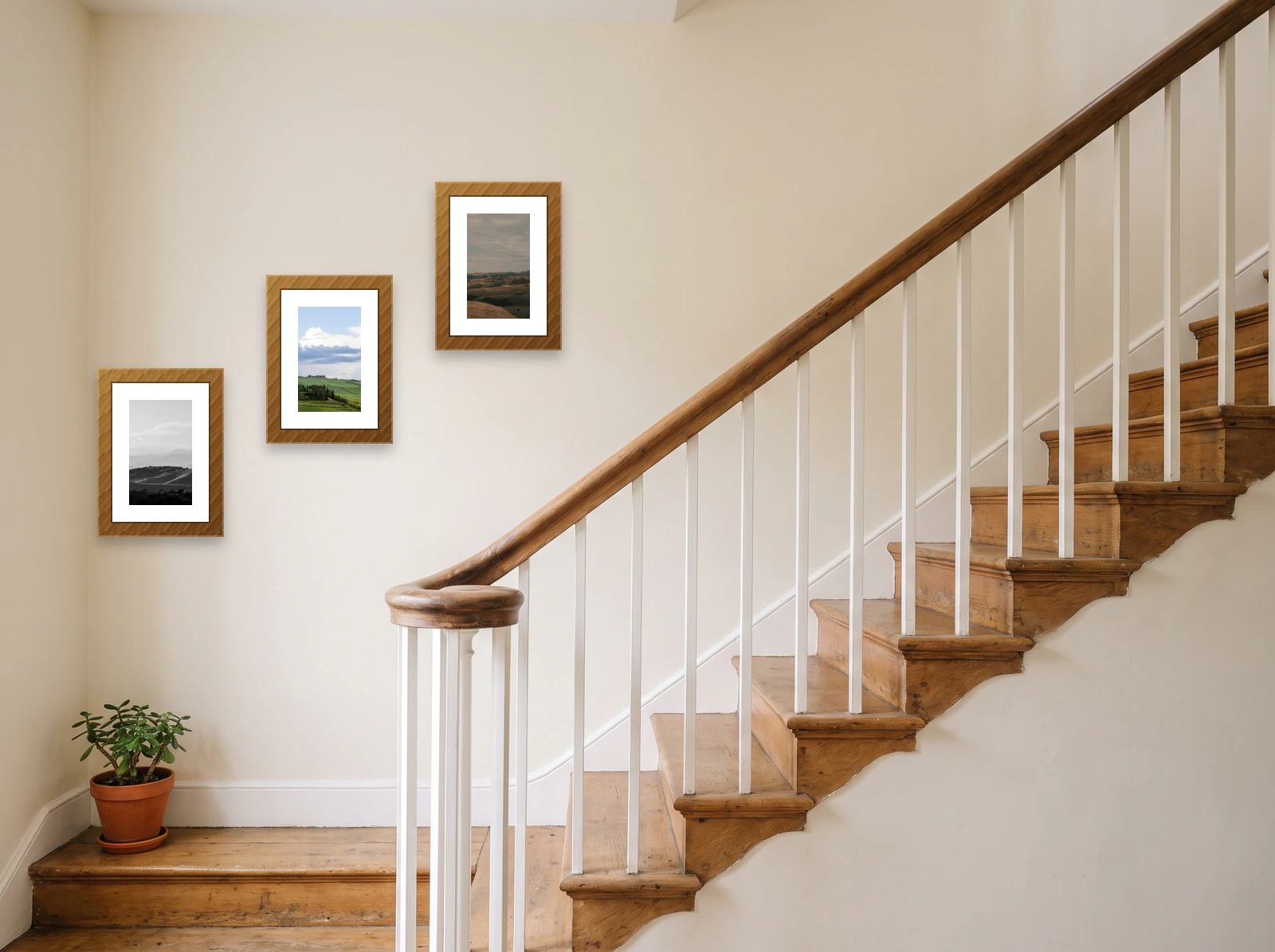 Stairway gallery wall template: three 30 × 40 cm wood frames climbing a cream wall beside a cottage staircase